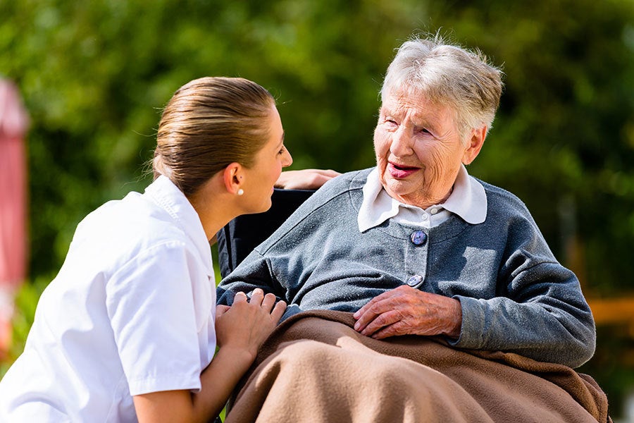 nurse helping senior in wheelchair