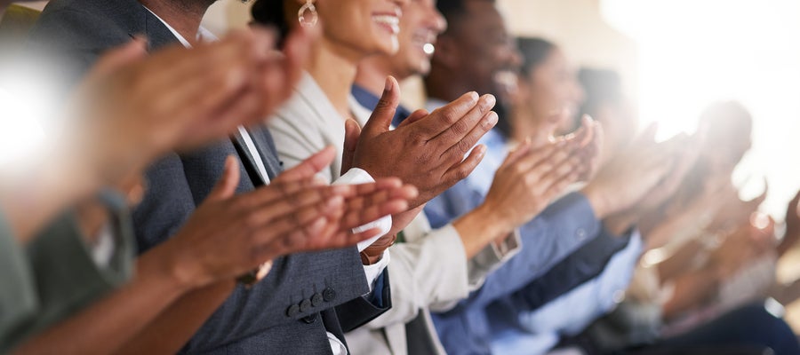 A row of people clap their hands. 