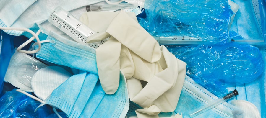 Gloves, masks, and other personal protective equipment sit in a pile.