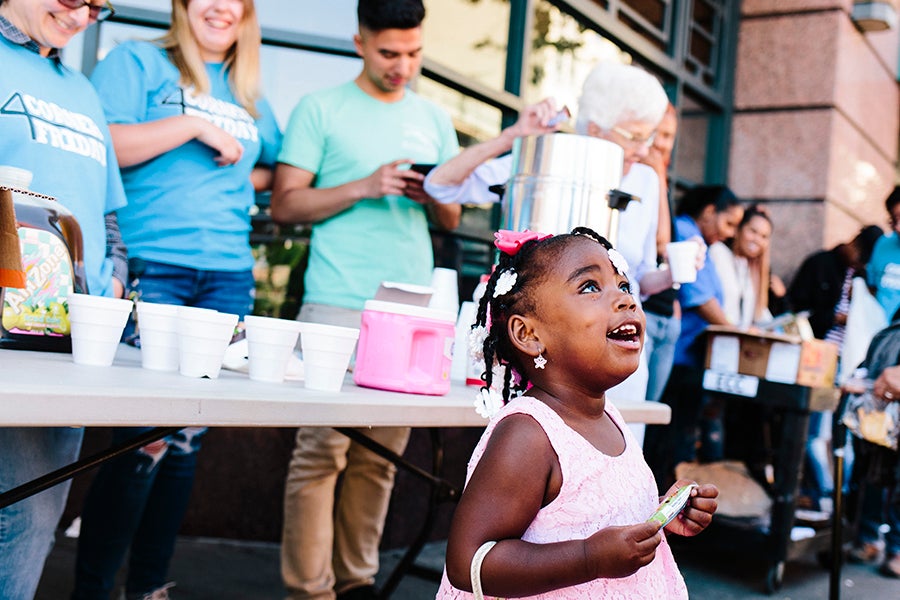toddler looking up as workers look on